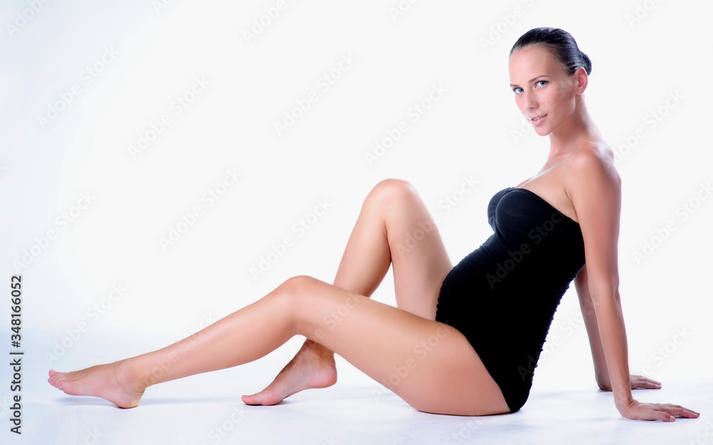 Obraz premium Portrait of smiling young pregnant fitness model in sportswear, studio shot
