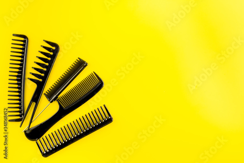 Hair salon tools. Combs on yellow table top view copy space