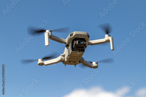 Small drone in flight on blue sky background