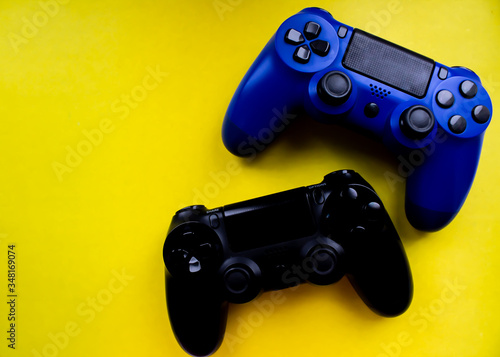 Blue and black joysticks for playstation 4 on a yellow background close-up