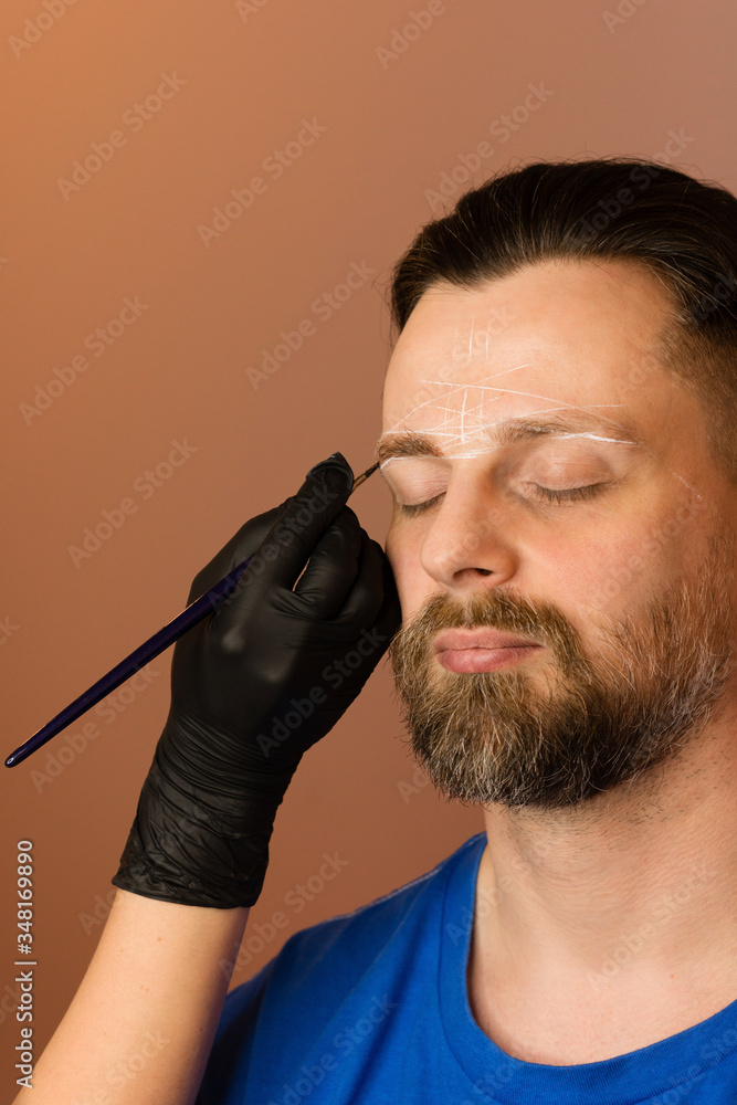 Permanent makeup for eyebrows. Tinting brows. Handsome man with