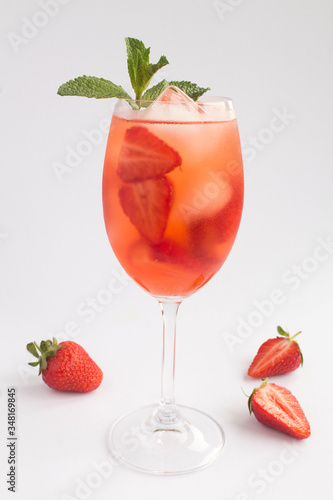 Cocktail drink with strawberry and ice in a glass on the white  background. Location vertical. Closeup.