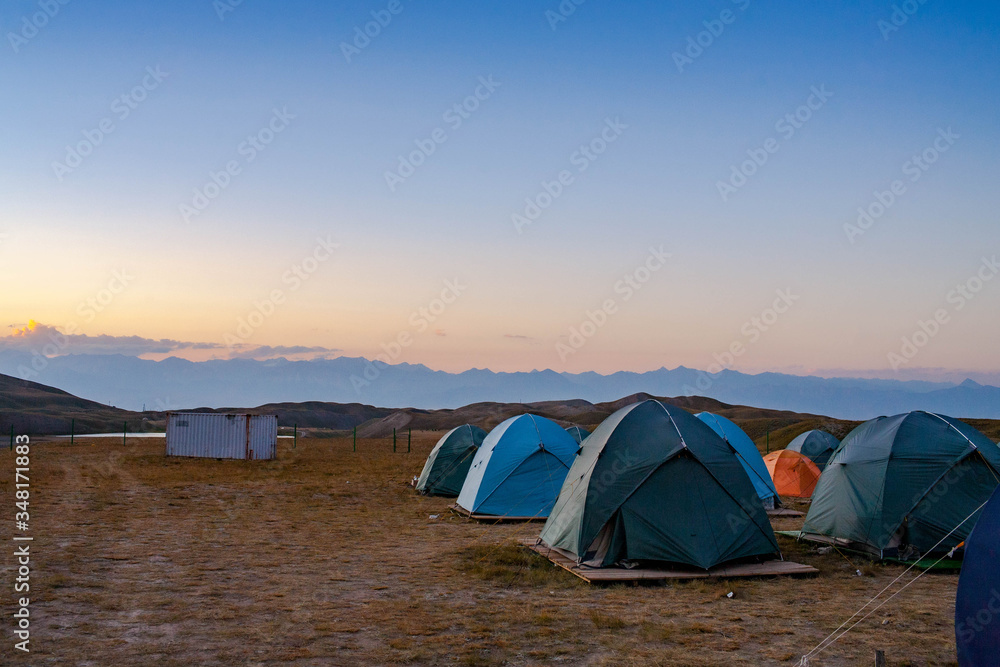 Scenic summer landscape of hilly area. Tent camp in the valley. Hiking. Lifestyle.
