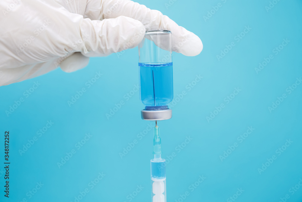 Fototapeta premium The doctor collects medicine from an ampoule into a syringe. Covid 19
