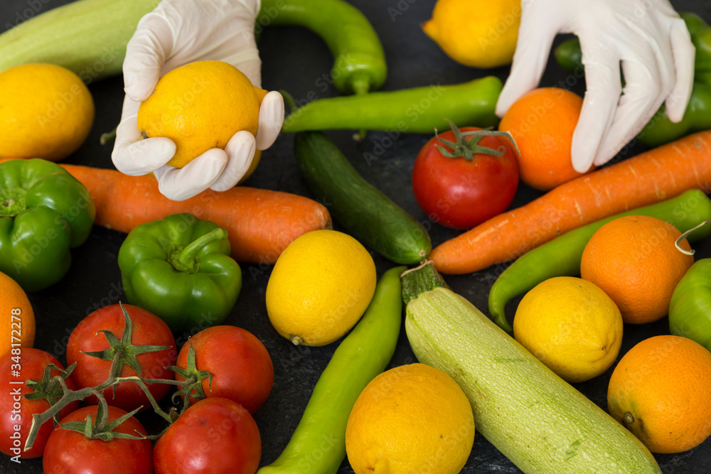 Choosing fruit with plastic medical gloves to protect from Covid-19 virus attack.