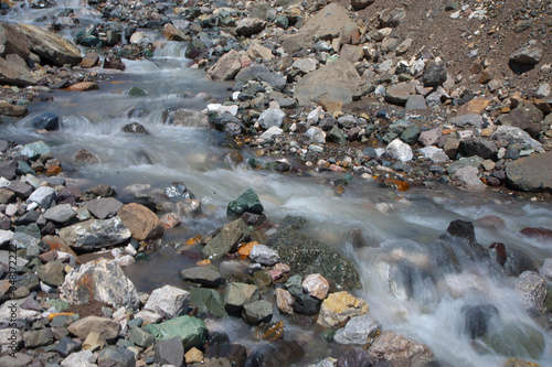 Close-up of the fast mountain stream between stones. Beautiful nature. © Aleks Kend