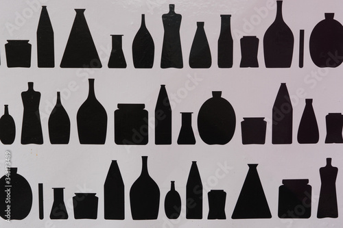 Abstrakter schwarz-weißer Hintergrund: Reihen von diversen Typen von Glasflaschen und Vasen 