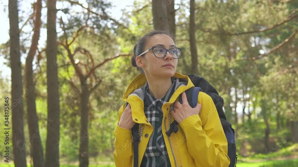 Young woman tourist with backpack walking in wild forest, slow motion. Travel and hiking concept Young woman tourist with backpack walking in wild forest, slow motion. Travel and hiking concept