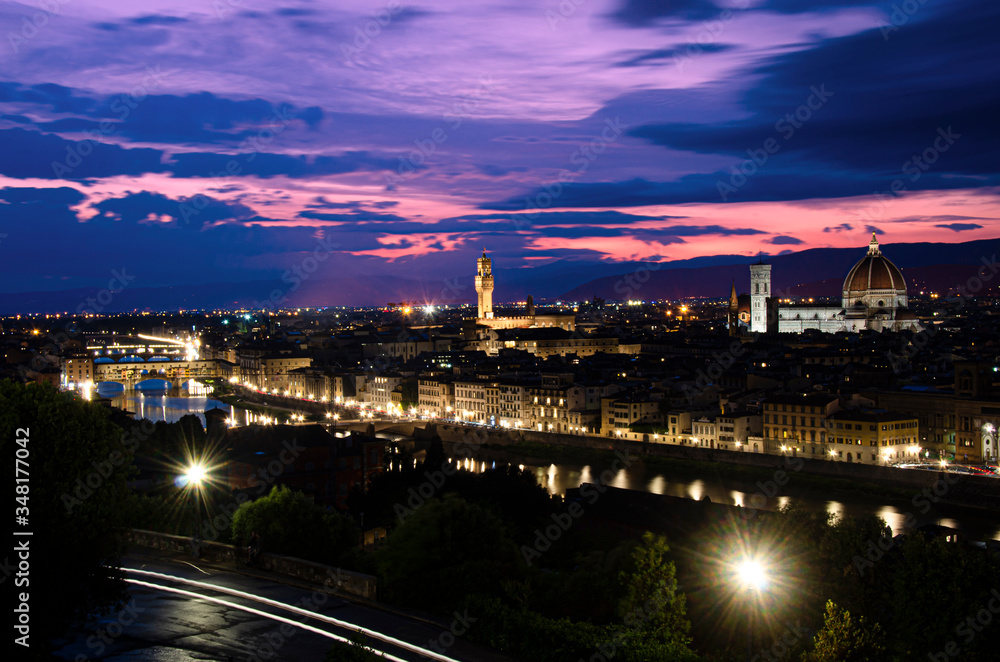 Night view of Florence during sunset from Michelangelo Square, Italy. Beautiful purple and pink sky with clouds over Florence at night.