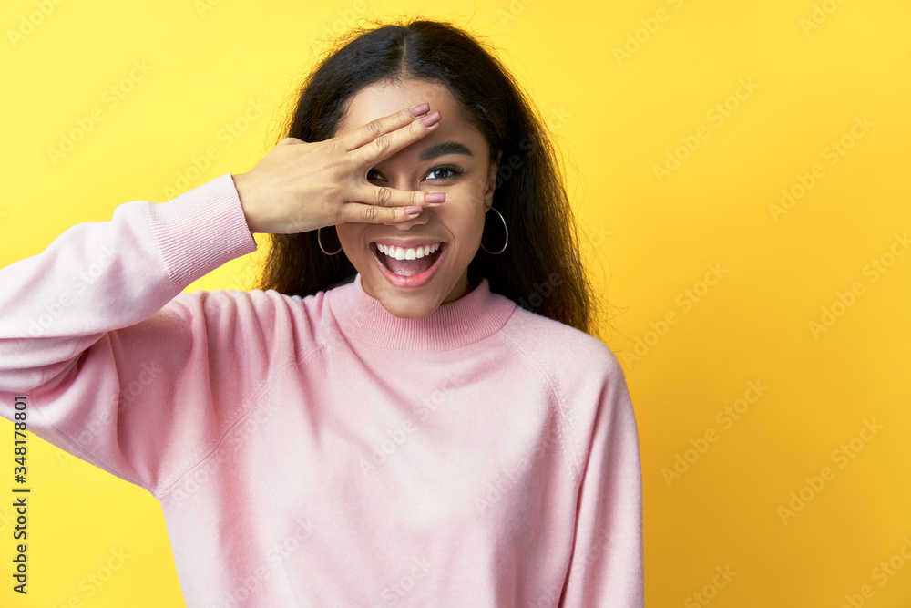 Smiling black woman looking through fingers clothing eyes with hand Smiling black woman looking through fingers clothing eyes with hand