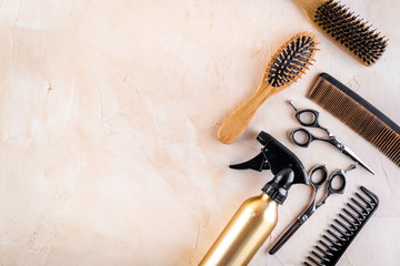 Hairdresser set in beauty salon. Combs, scissors, spray on beige desk top-down copy space