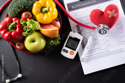 World diabetes day and healthcare concept. Patient's blood sugar control, diabetic measurement, and healthy food eating nutrition with red heart on black background.