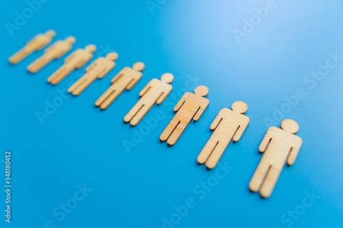 Wooden figures on blue background as a symbol of team building. Organization group people in business. Cooperation and partnership.