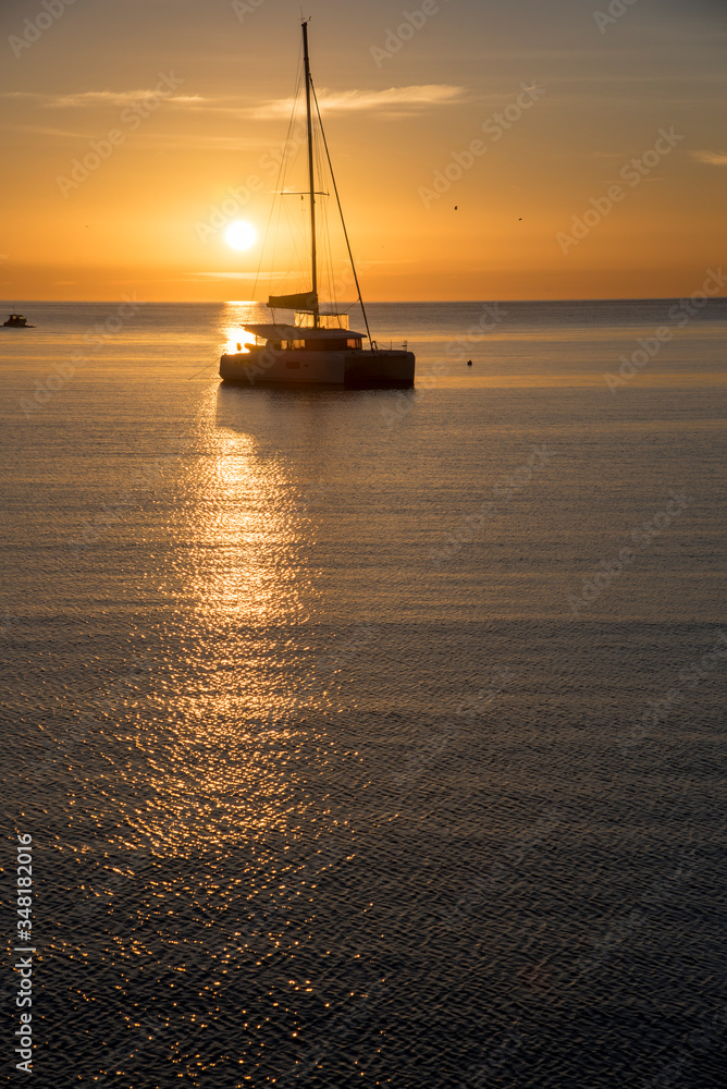 Sunrise with catamaran at the mouth of the port of Aguilas, Spain.