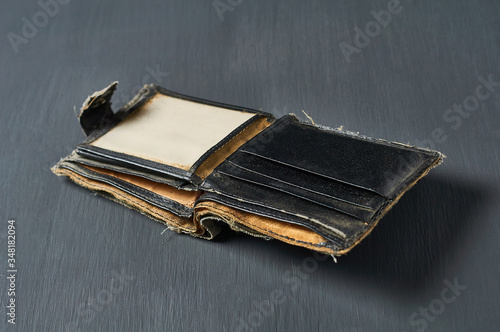 Old battered empty wallet on concrete desk. Concept of social poverty and unemployment photo