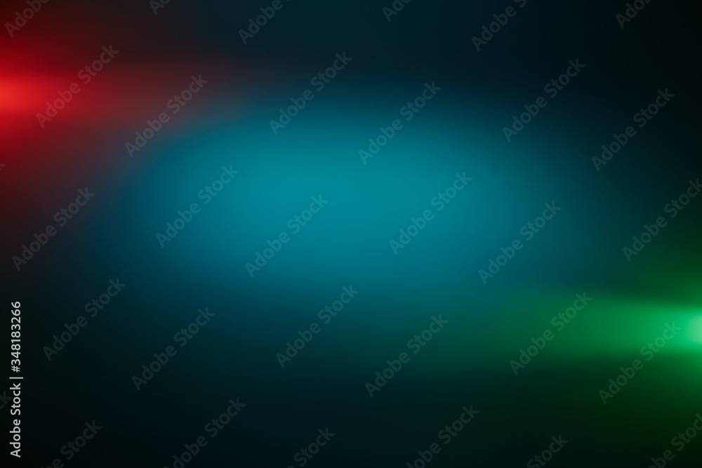 Around a dark turquoise volumetric cloud of light, short green and red rays of light