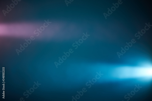 On a dark blue background pink and light blue rays of light