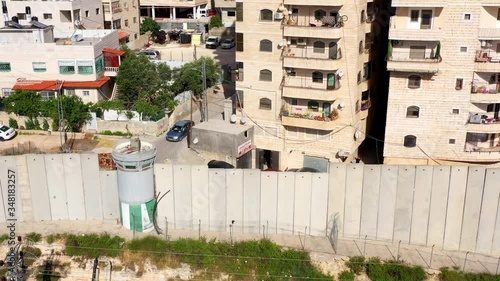 Security wall with Israeli idf watch tower Close to Shuafat Refugee Camp- Aerial
Crowded refugee camp, Israel, Jerusalem- May/10,2020
 photo