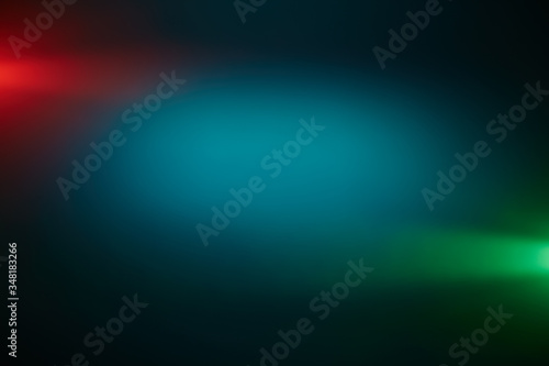 Around a dark turquoise volumetric cloud of light  short green and red rays of light