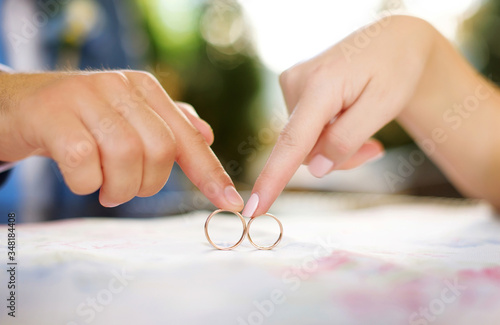 bride and groom holding wedding rings