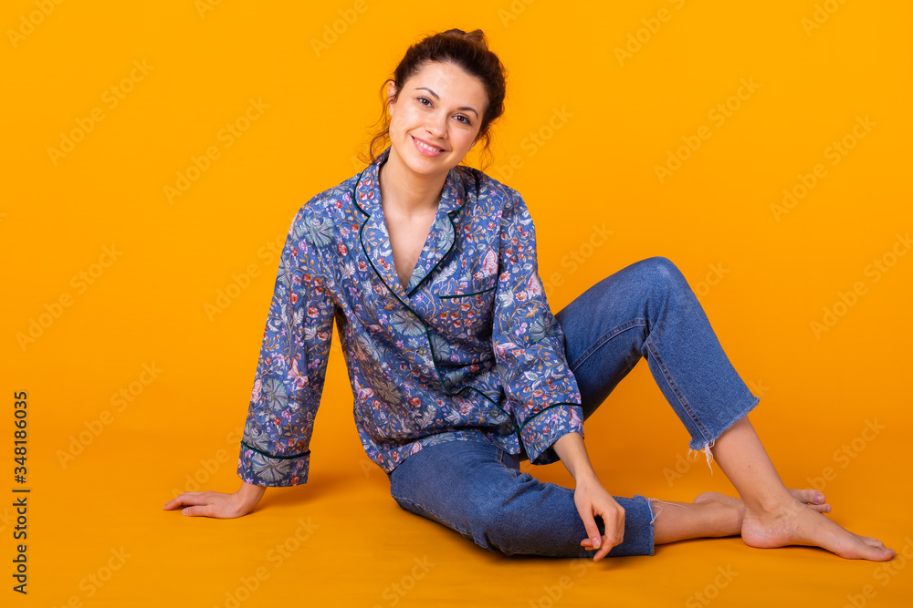 Excited young woman in blue home wear, widely smiling having fun. Isolated on yellow background. Excited young woman in blue home wear, widely smiling having fun. Isolated on yellow background.