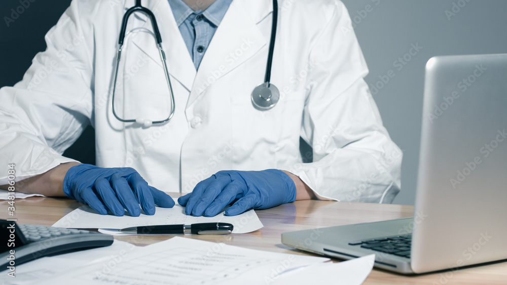 Doctor looking at medical files working with coputer Doctor looking at medical files working with coputer