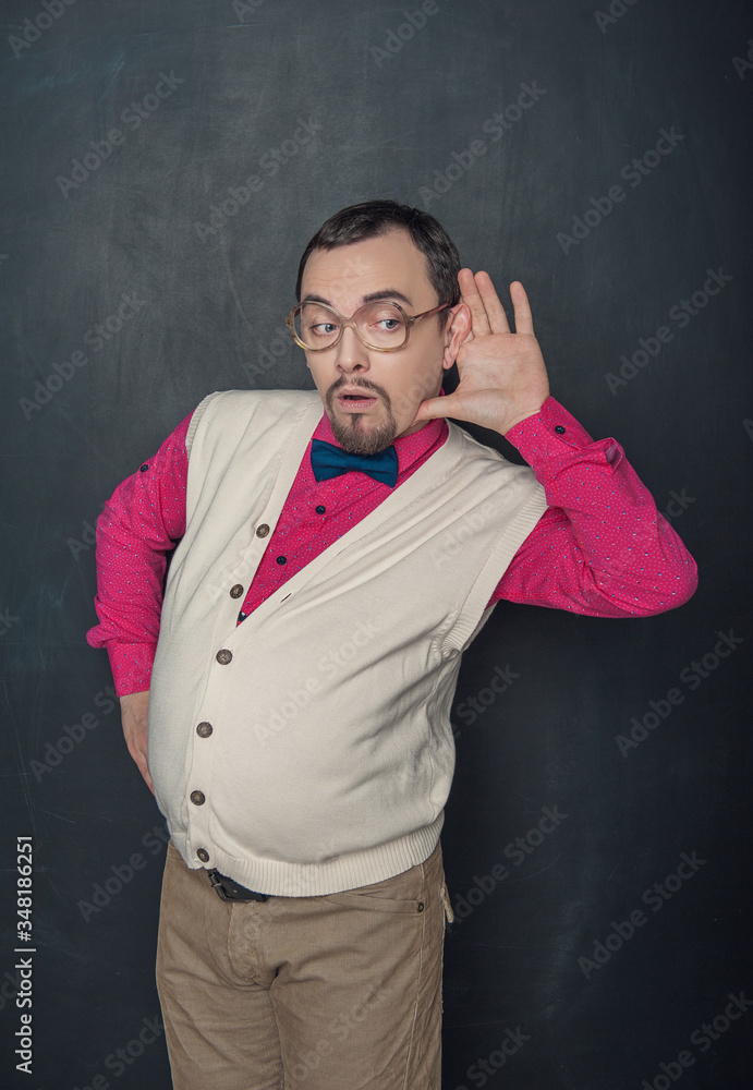 Funny thick teacher or business man with hand near his ear on blackboard