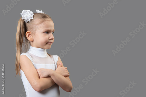 Portrait of a beautiful caucasian little displeased girl arms folded, closed pose. The idea of child discontent on the actions of adults. Place for text, copyspace