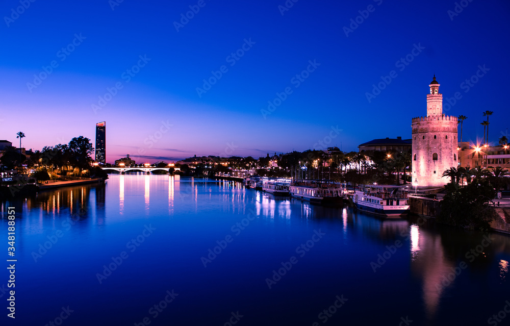 VIEW OF THE GUADALQUIVIR RIVER IN THE BLUE HOUR WITH THE TOWER OF GOLD IN THE CLOSE-UP