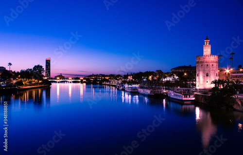 VIEW OF THE GUADALQUIVIR RIVER IN THE BLUE HOUR WITH THE TOWER OF GOLD IN THE CLOSE-UP