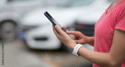 Woman using smartphone at outdoor parking lot