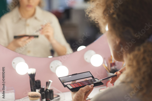 Tableau sur toile Back view close up of unrecognizable young woman holding eyeshadow palette while