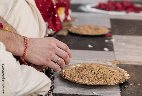 Hindu bride and groom held grain in their hands, participating in the wedding ritual. Beautiful traditional Indian wedding ceremony. Hindu wedding. indian engagement. Hindu the Vedic Yagya ceremony