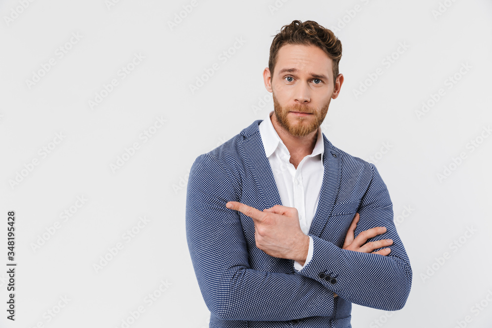 Image of handsome young man posing and pointing finger aside Image of handsome young man posing and pointing finger aside