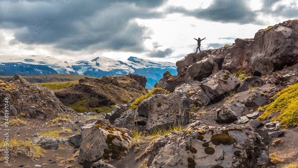 Fototapeta premium A young woman on top of a mound on the 4-day trek from Landmannalaugar. Iceland