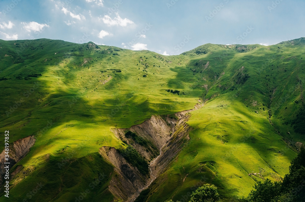 Mountain landscape with green grass and cleft.