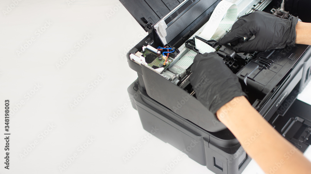 Printer repairman inspecting printer interior.Copy space. Concept of professional printer maintenance Technical assistance in office hardware Continuous repair of the ink system. Printer problems .. Printer repairman inspecting printer interior.Copy space. Concept of professional printer maintenance Technical assistance in office hardware Continuous repair of the ink system. Printer problems ..