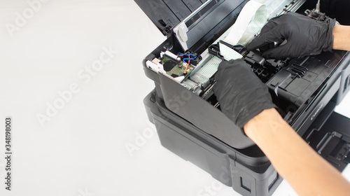 Printer repairman inspecting printer interior.Copy space. Concept of professional printer maintenance Technical assistance in office hardware Continuous repair of the ink system. Printer problems ..