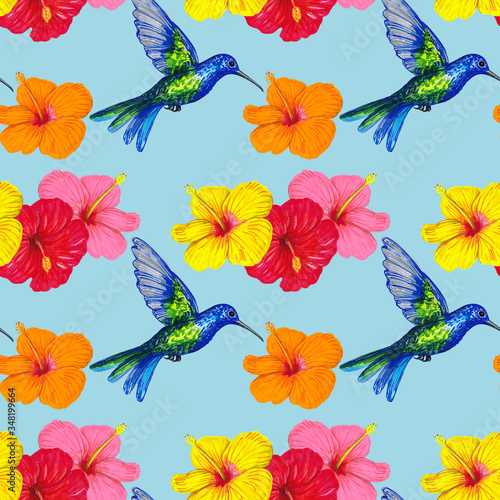 Colibri bird with colorful hibiscus flowers on a blue background. Tropical seamless pattern design for wallpaper, paper, textile, fabric.
