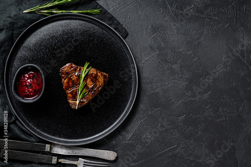 Grilled filet Mignon steak. Beef tenderloin. Black background. Top view. Space for text