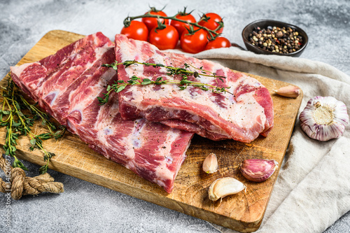 Farm organic meat. Raw pork ribs with rosemary, pepper and garlic. Gray background. Top view