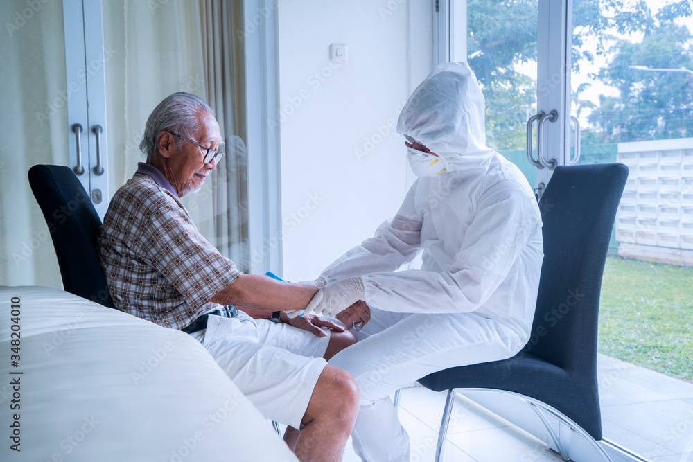 Doctor in hazmat suit checking senior man pulse Doctor in hazmat suit checking senior man pulse