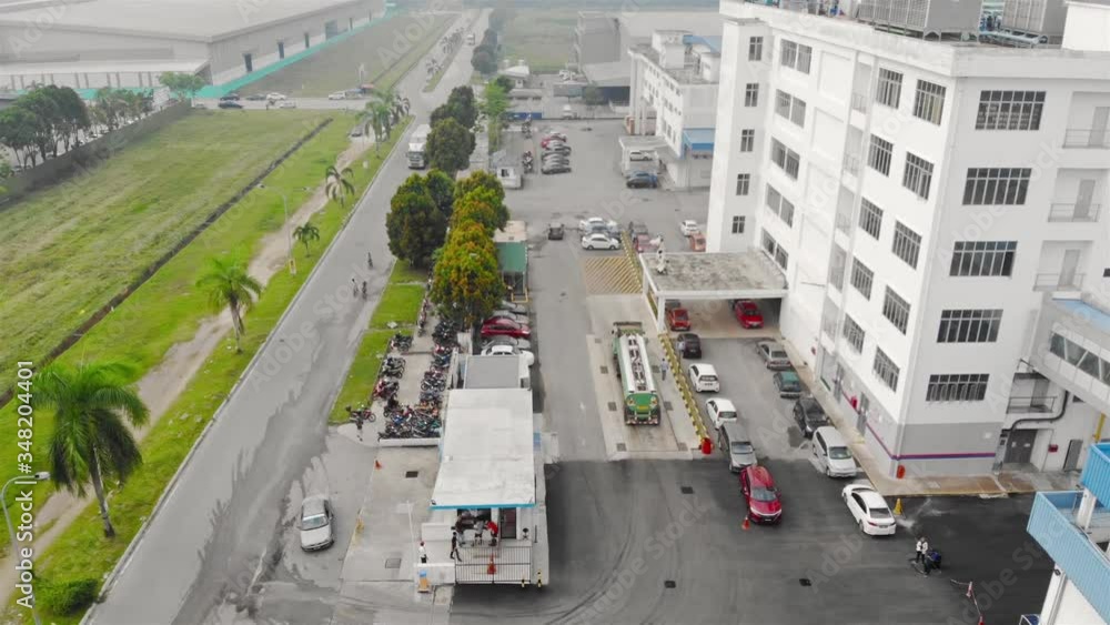 Foggy compound of factory with car park as vehicle pass by out side premise - descending Foggy compound of factory with car park as vehicle pass by out side premise - descending
