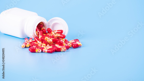 Red capsule spilled on white background