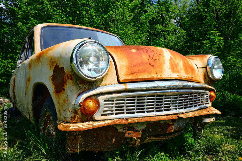 Rusty old car among the green bushes in summer. Rusty old car among the green bushes in summer.