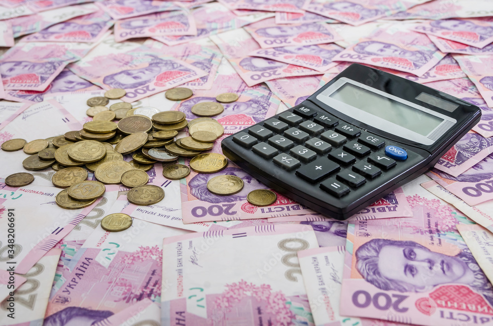 Ukrainian pennies and a calculator on the background of hryvnia. Much money. Ukrainian pennies and a calculator on the background of hryvnia. Much money.