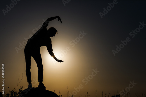 Silhouette of a man on a background of sunset. © gladiusstock