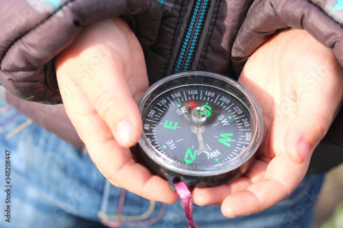 Old classic navigation compass in childs hands