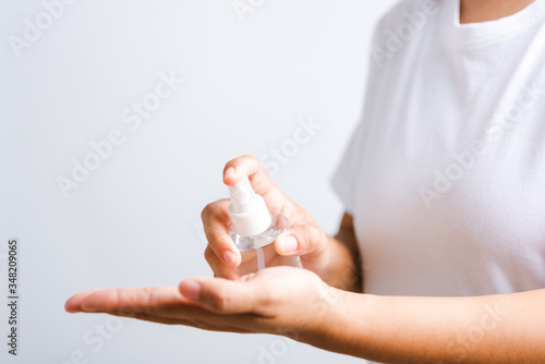 Closeup Hand Asian young woman applying spray pump dispenser sanitizer alcohol on hand wash cleaning, hygiene prevention COVID-19 or coronavirus protection concept, isolated on white background