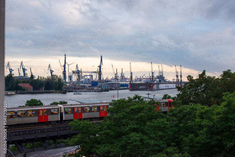 Obraz premium view of the port of hamburg over the elevated railway to the shipyard cranes